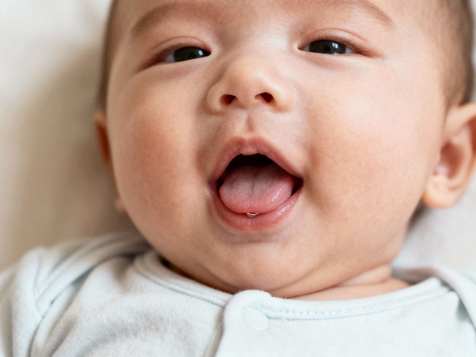 An infant with their tongue out — tongue-tie can restrict normal tongue movement.